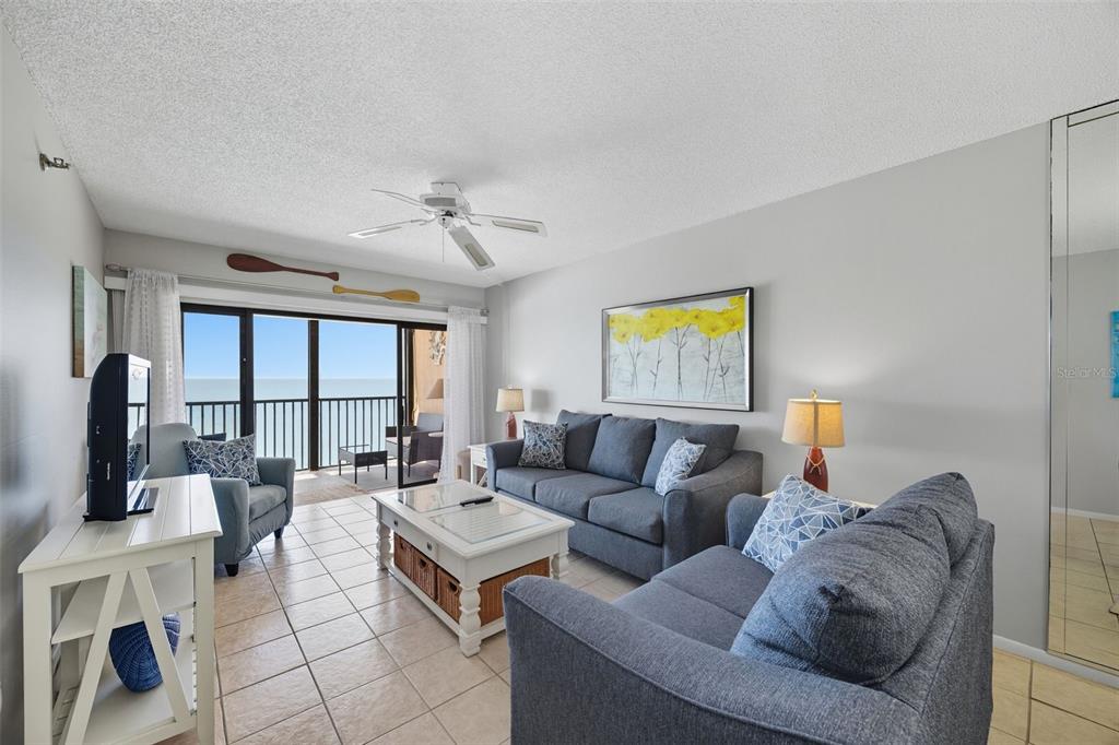 13720 Gulf Boulevard, Unit 609 Madeira Beach, FL 33708 - Photo 11 of 40 a living room with furniture a flat screen tv and a large window
