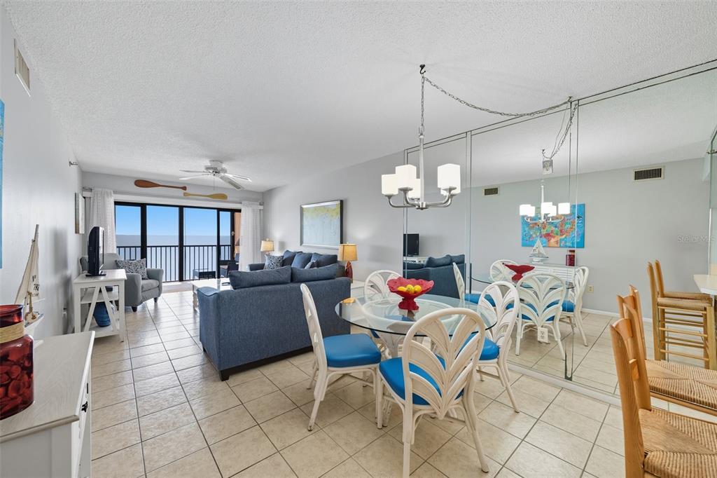 13720 Gulf Boulevard, Unit 609 Madeira Beach, FL 33708 - Photo 14 of 40 a living room with lots of furniture and a chandelier