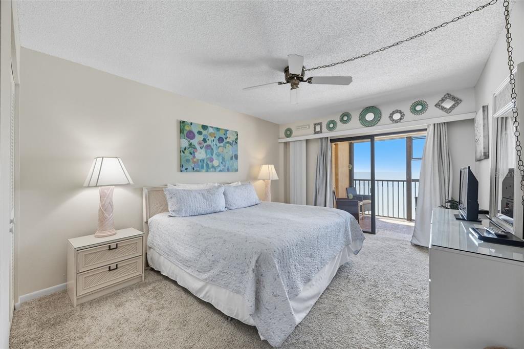 13720 Gulf Boulevard, Unit 609 Madeira Beach, FL 33708 - Photo 18 of 40 a bedroom with a large bed and a flat tv screen on dresser