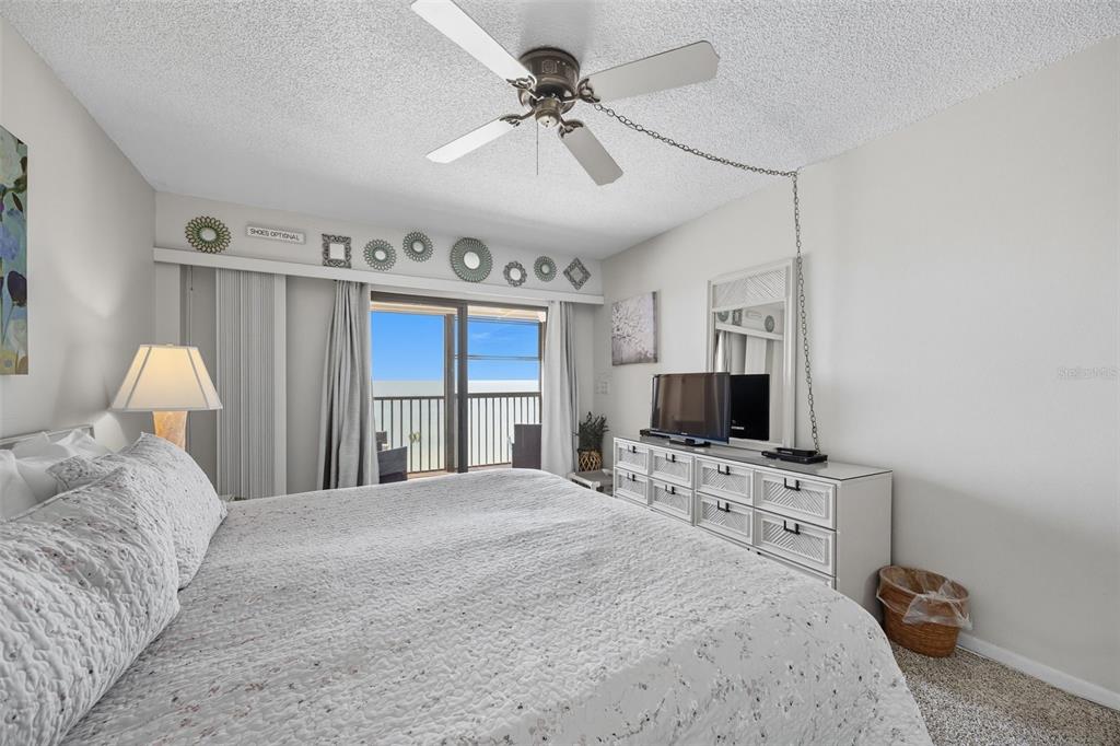 13720 Gulf Boulevard, Unit 609 Madeira Beach, FL 33708 - Photo 19 of 40 a bedroom with a bed a window and a flat screen tv