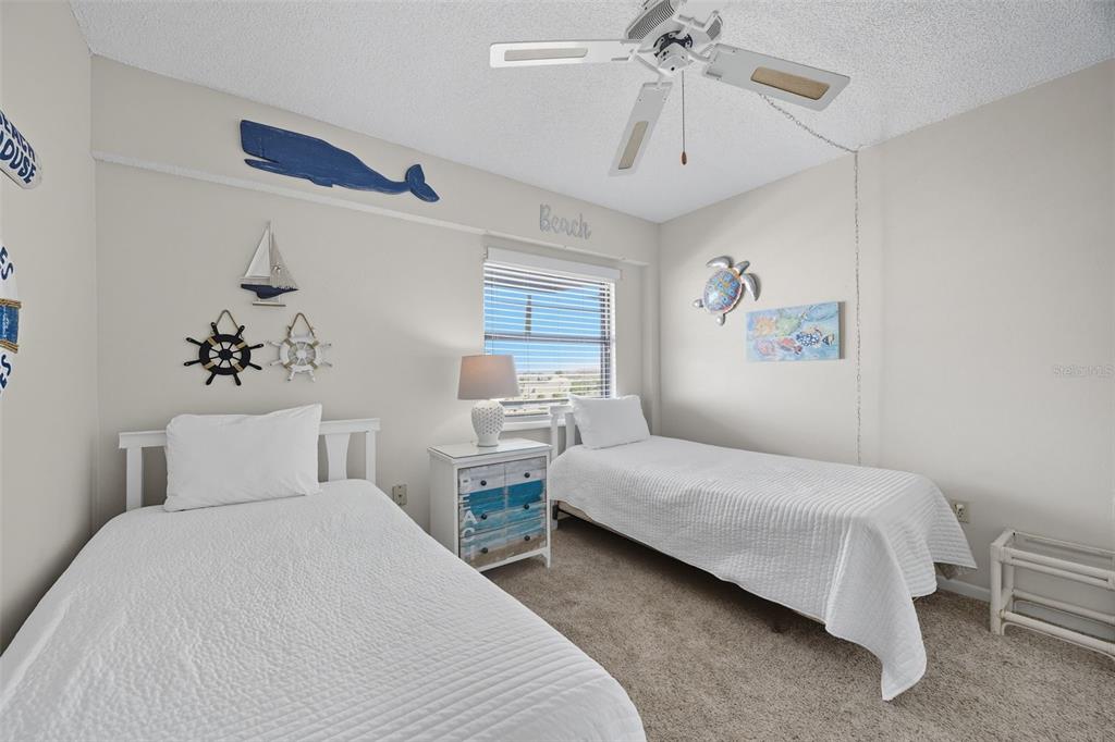13720 Gulf Boulevard, Unit 609 Madeira Beach, FL 33708 - Photo 20 of 40 a bedroom with a large bed and a chandelier