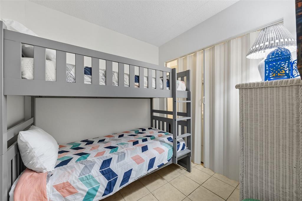 13720 Gulf Boulevard, Unit 609 Madeira Beach, FL 33708 - Photo 23 of 40 a bedroom with a bed and a chandelier