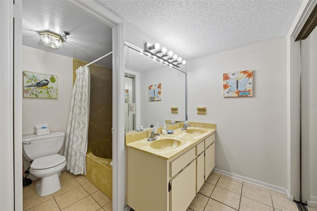 13720 Gulf Boulevard, Unit 609 Madeira Beach, FL 33708 - Photo 25 of 40 a bathroom with a toilet sink and mirror