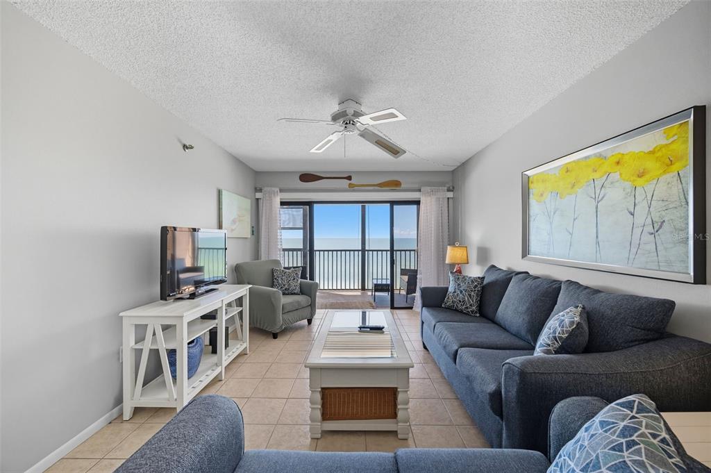 13720 Gulf Boulevard, Unit 609 Madeira Beach, FL 33708 - Photo 10 of 40 a living room with furniture and a flat screen tv