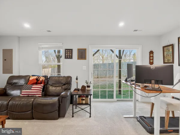 a living room with furniture a flat screen tv and a window