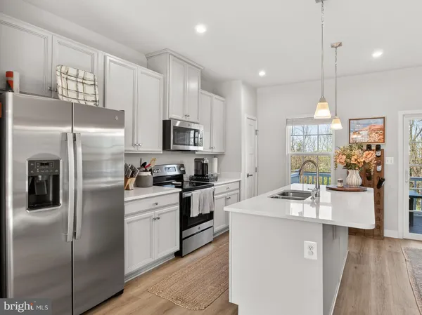 a kitchen with kitchen island granite countertop stainless steel appliances cabinets a sink and a counter top space