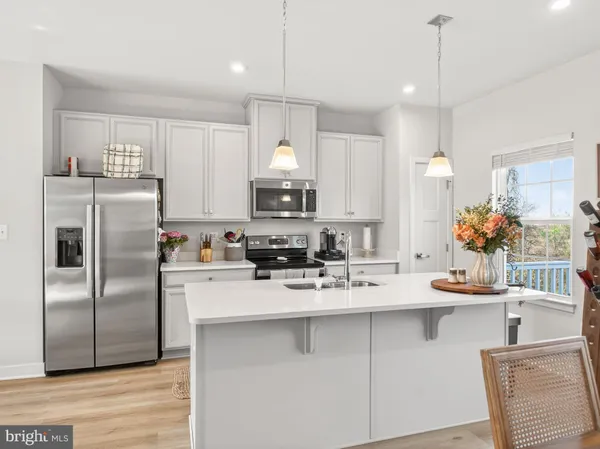 a kitchen with kitchen island a sink stove and refrigerator