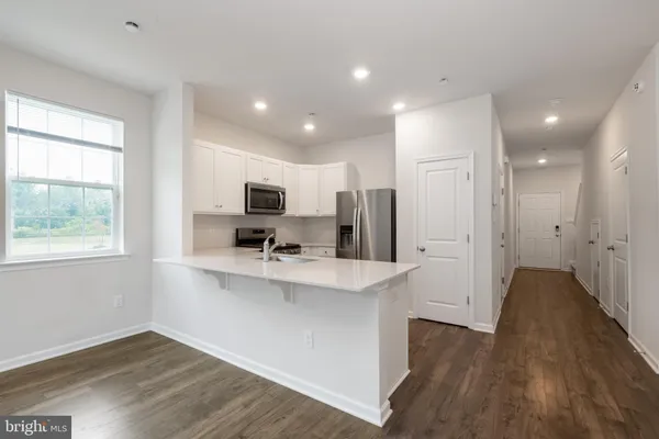 a living room with furniture and kitchen view
