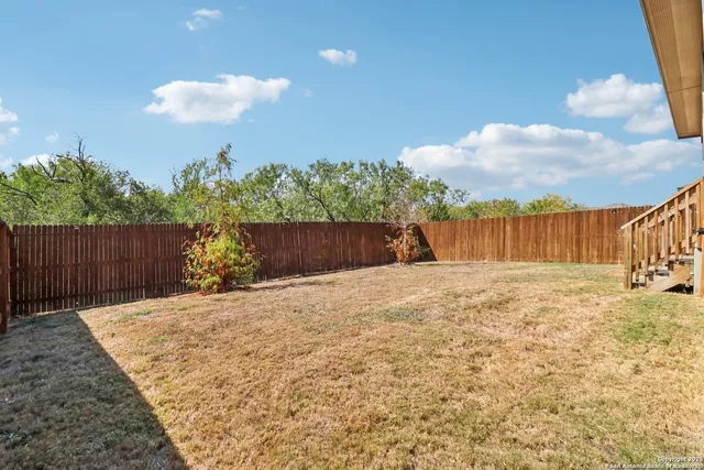 a view of backyard with wooden fence