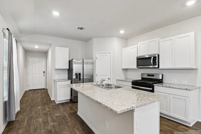 a kitchen with stainless steel appliances granite countertop a sink stove and refrigerator