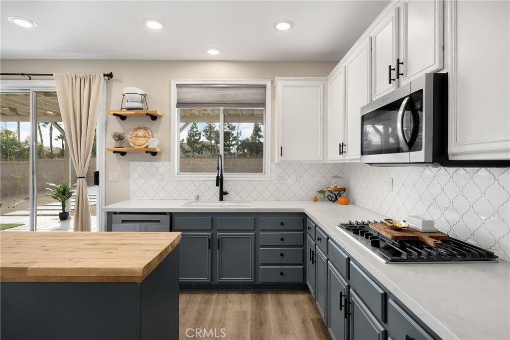 6861 Rio Grande Drive Eastvale, CA 91752 - Photo 14 of 36 a kitchen with stainless steel appliances a sink stove and cabinets