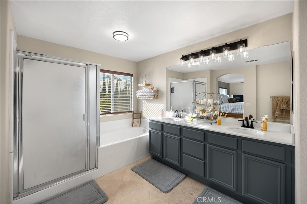 6861 Rio Grande Drive Eastvale, CA 91752 - Photo 19 of 36 a bathroom with a double vanity sink a mirror and a bathtub