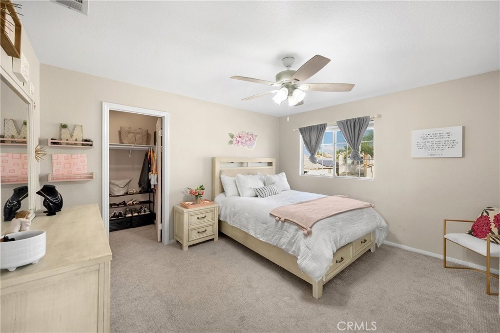 6861 Rio Grande Drive Eastvale, CA 91752 - Photo 22 of 36 a spacious bedroom with a bed and a chandelier