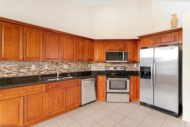 a kitchen with stainless steel appliances granite countertop a stove top oven a sink and dishwasher