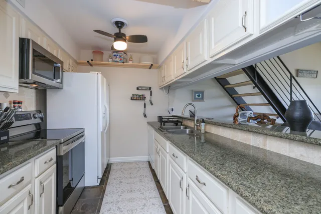 a kitchen with stainless steel appliances granite countertop a sink a stove and a refrigerator