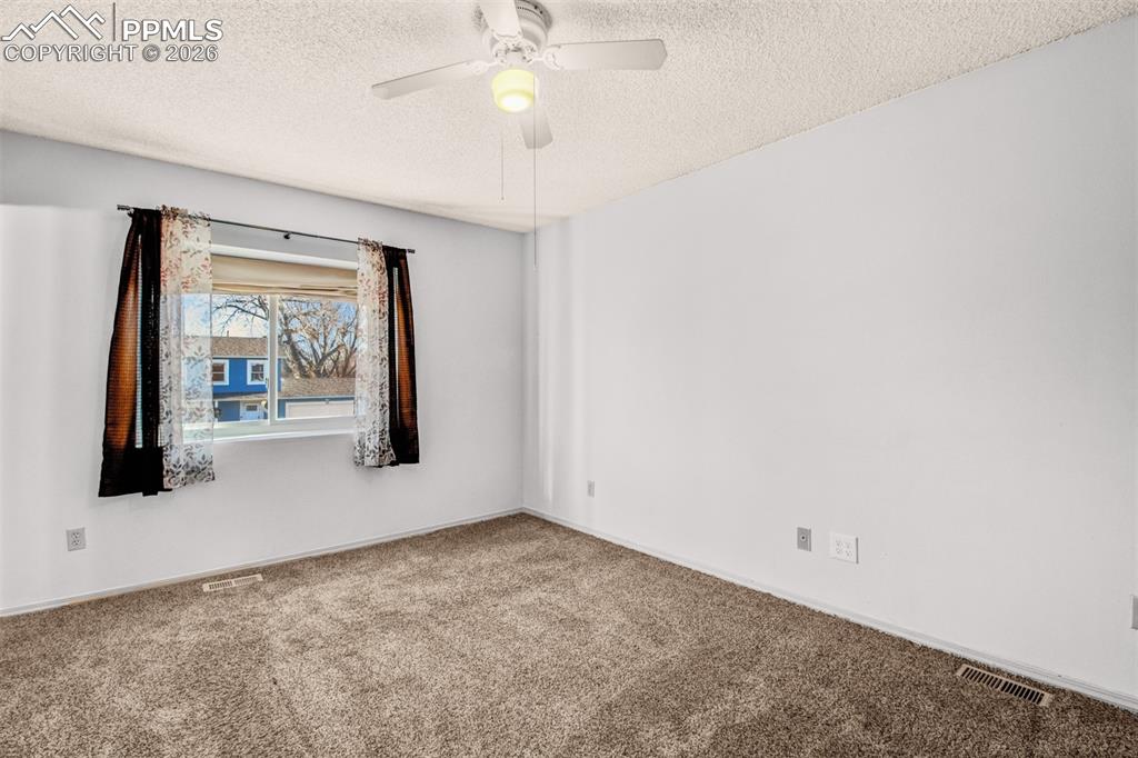541 Blossom Field Road Fountain, CO 80817 - Photo 13 of 35 an empty room with chandelier fan and windows