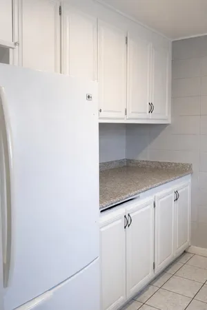 a kitchen with white cabinets and white appliances