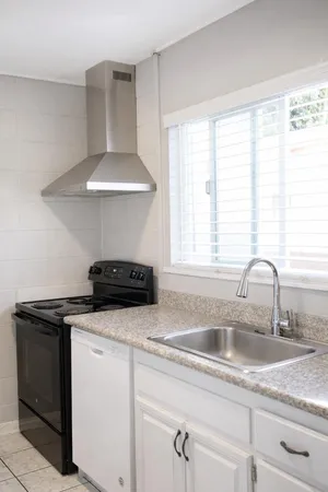 a kitchen with a sink a stove and cabinets