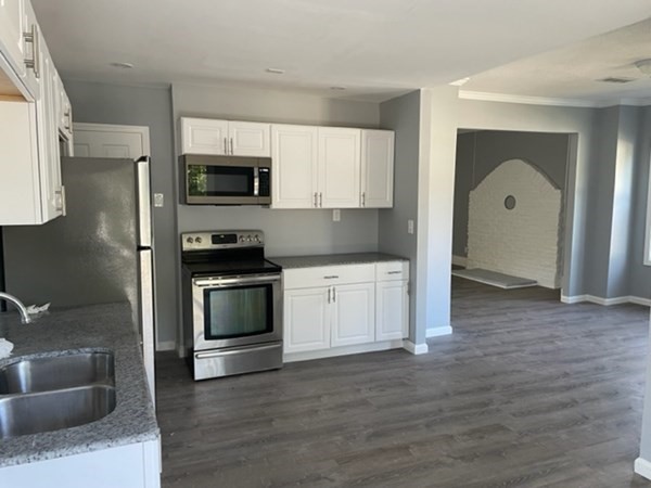 253 Draper Street Springfield, MA 01108 - Photo 15 of 38 a kitchen with granite countertop a refrigerator and a stove top oven