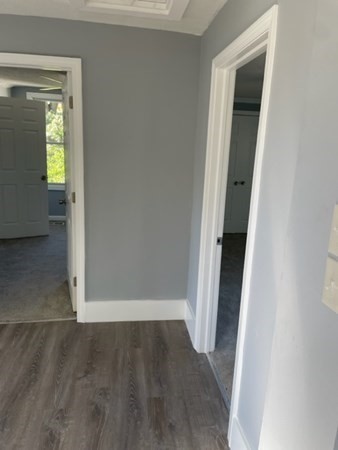 253 Draper Street Springfield, MA 01108 - Photo 22 of 38 an empty room with wooden floor and a hallway