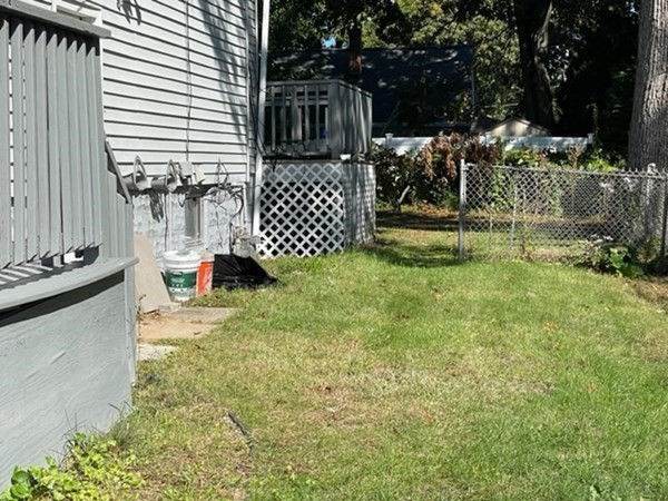 253 Draper Street Springfield, MA 01108 - Photo 31 of 38 a view of a yard with yellow house and wooden fence
