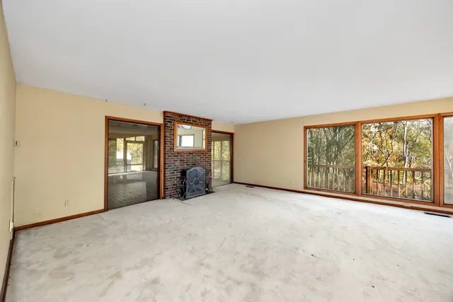 a view of empty room with a fireplace and window