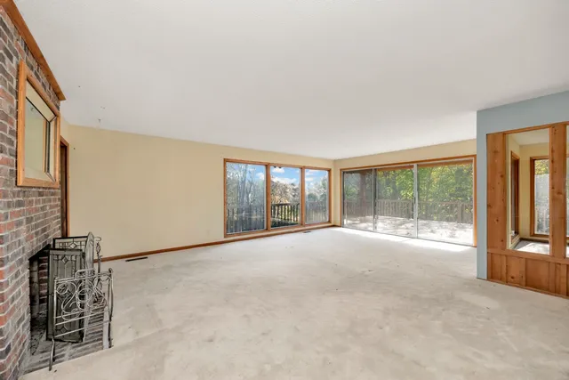 a view of an empty room with a window and cabinet