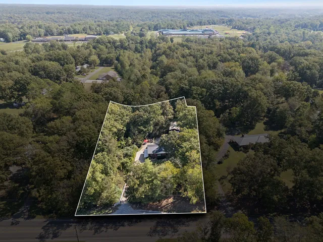 a large white kitchen with sink a window and stainless steel appliances