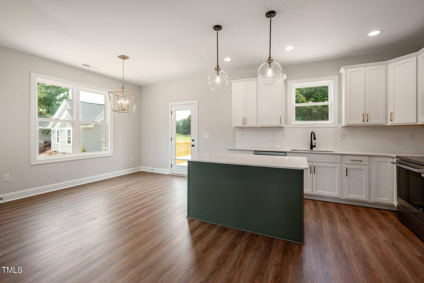 9600 Stallings Road Spring Hope, NC 27882 - Photo 8 of 29 a kitchen with granite countertop wooden floors white cabinets and window