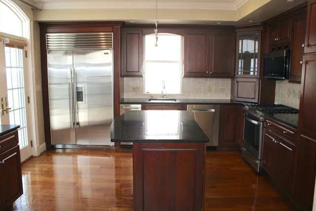 a kitchen with kitchen island a counter top space appliances and a window