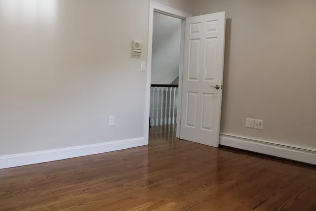 an empty room with wooden floor and closet