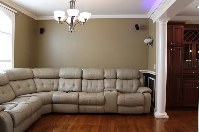 a living room with furniture chandelier and a wooden floor