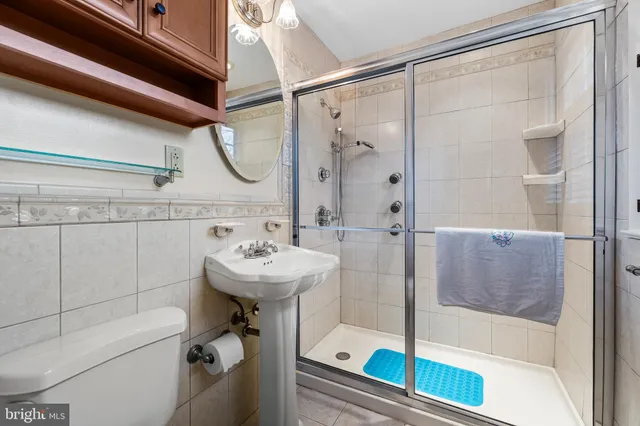 a view of a hallway with wooden floor and a bathroom