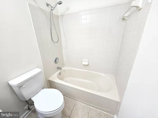 a white toilet sitting next to a bath tub shower