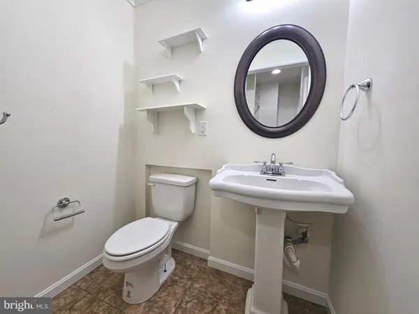 a bathroom with a sink a toilet and a mirror
