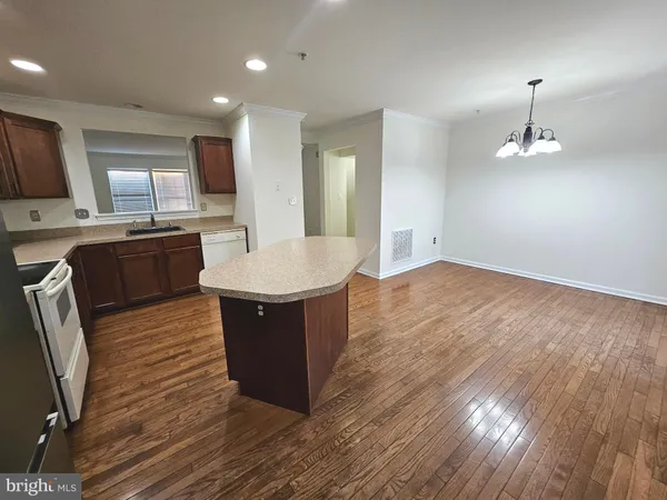 a large kitchen with stainless steel appliances wooden floors and wooden cabinets