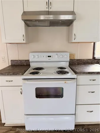 a kitchen with a refrigerator a stove top oven a sink and cabinets