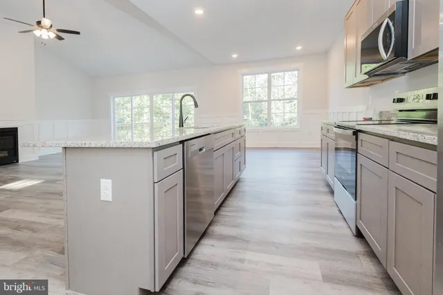 a kitchen with stainless steel appliances a refrigerator and a stove top oven
