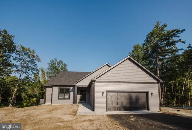 a view of a white house with a large tree