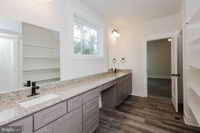 a bathroom with a granite countertop sink mirror and shower