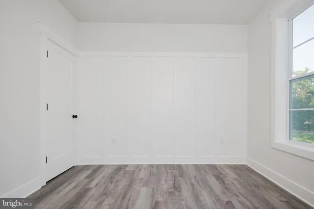 a view of small space with wooden floor and a window