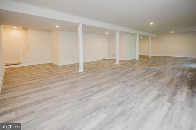 a view of an empty room with wooden floor