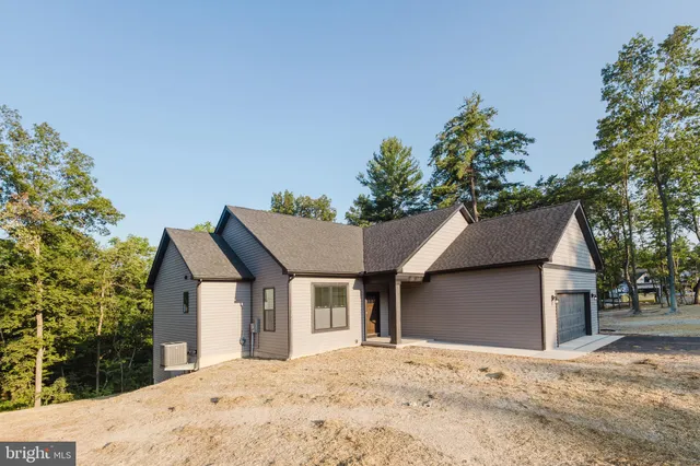 a view of a house with a yard and large tree