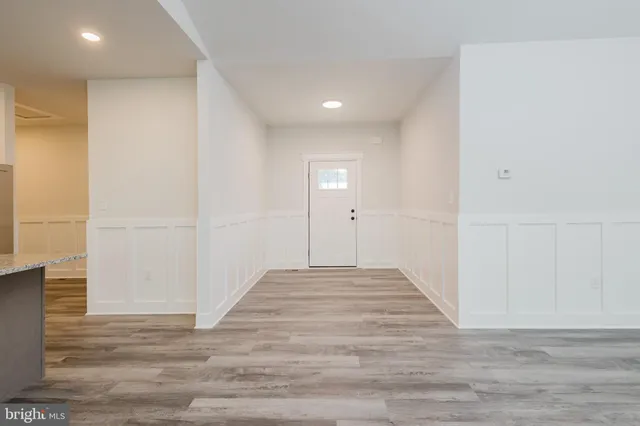 a kitchen with stainless steel appliances granite countertop a sink a stove and a refrigerator with wooden floor