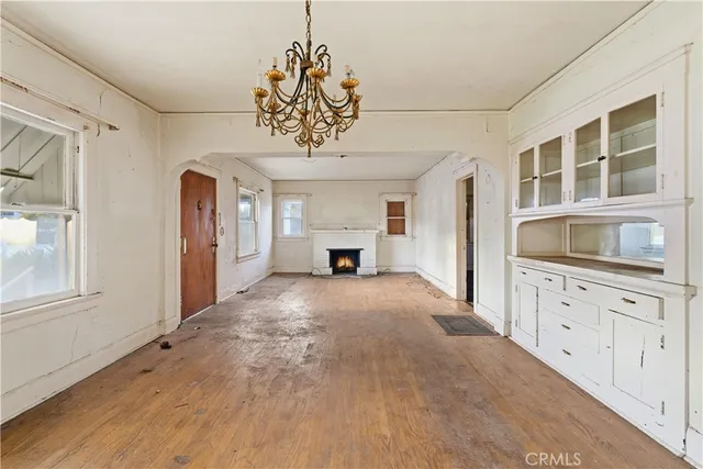 a view of an empty room with a window and cabinet