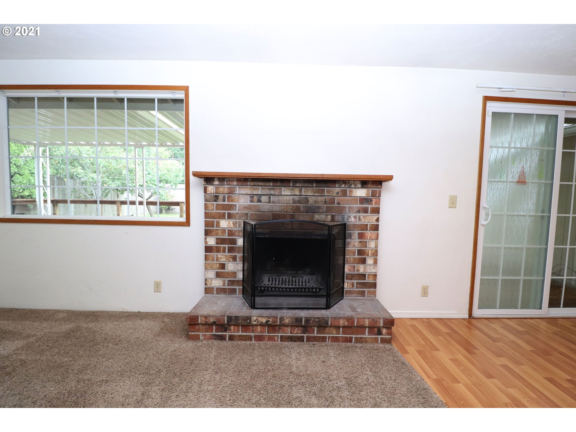 2310 6th Street Springfield, OR 97477 - Photo 4 of 32 a living room with a fireplace and a floor to ceiling window