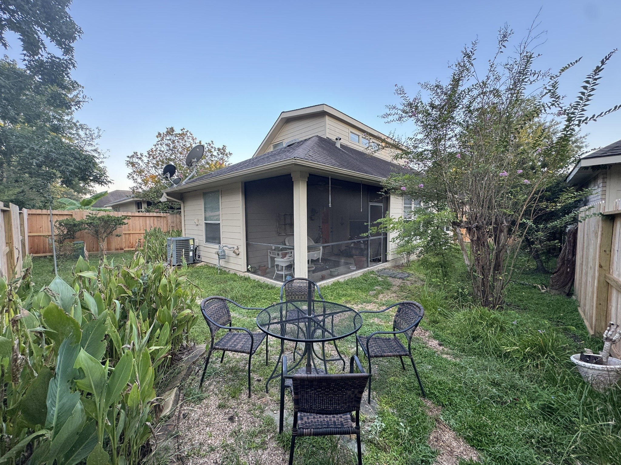 51 North Country Gate Circle Conroe, TX 77384 - Photo 24 of 27 The yard is enclosed by a wooden fence, has lush greenery, and a screened porch attached to the house. Ideal for outdoor relaxation and entertaining.