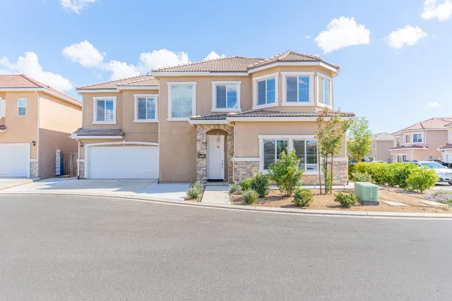 a front view of a house with a garden and plants