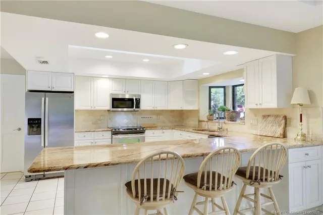a kitchen with a refrigerator and white cabinets