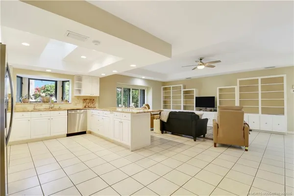 a kitchen with a chair and white cabinets